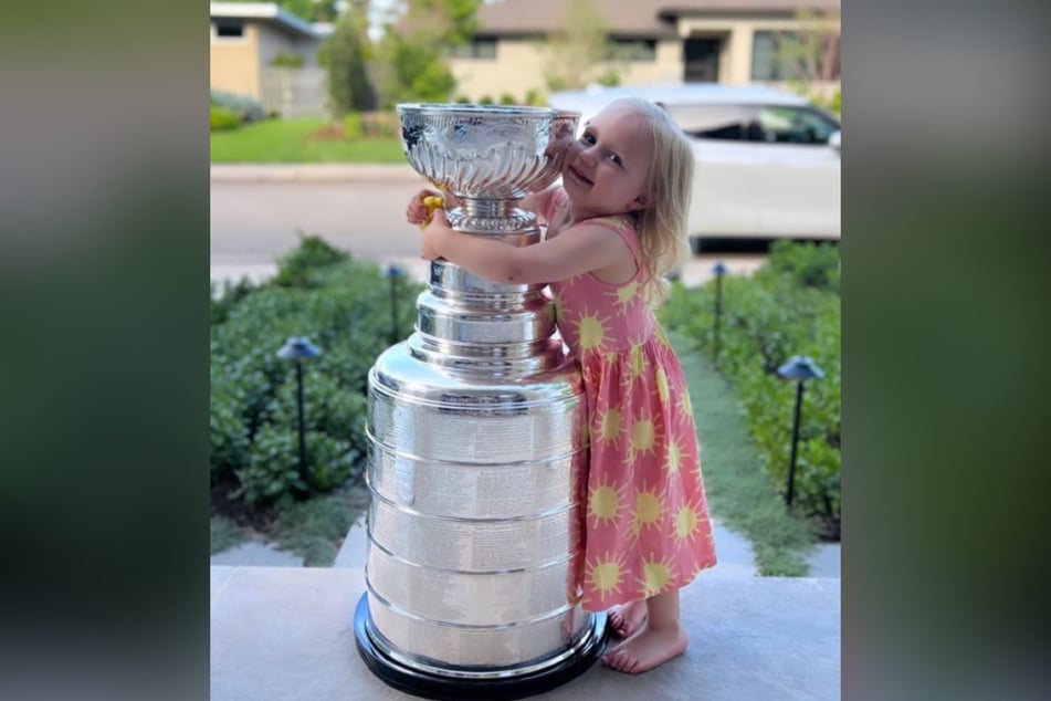 Gabriel Landeskog's daughter, Linnea Rae, and the famed Stanley Cup trophy.