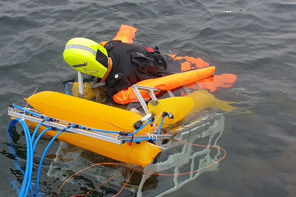 Ein Taucher demonstriert mit einem Tauchroboter die Rettung von Ertrinkenden.