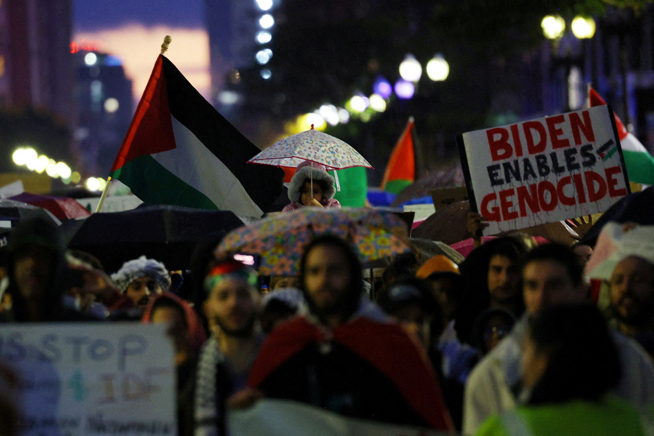 Demonstrators, including one carrying a sign that reads "Biden Enables Genocide," march in support of Palestinian freedom in Boston, Massachusetts.