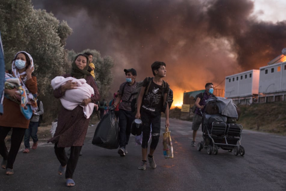 Migranten fliehen im September vor neu ausgebrochenen Feuern mit ihren Habseligkeiten aus dem Flüchtlingslager Moria. Baden-Württemberg wird nach Angaben des Innenministeriums voraussichtlich rund 85 Menschen aus dem Camp aufnehmen.