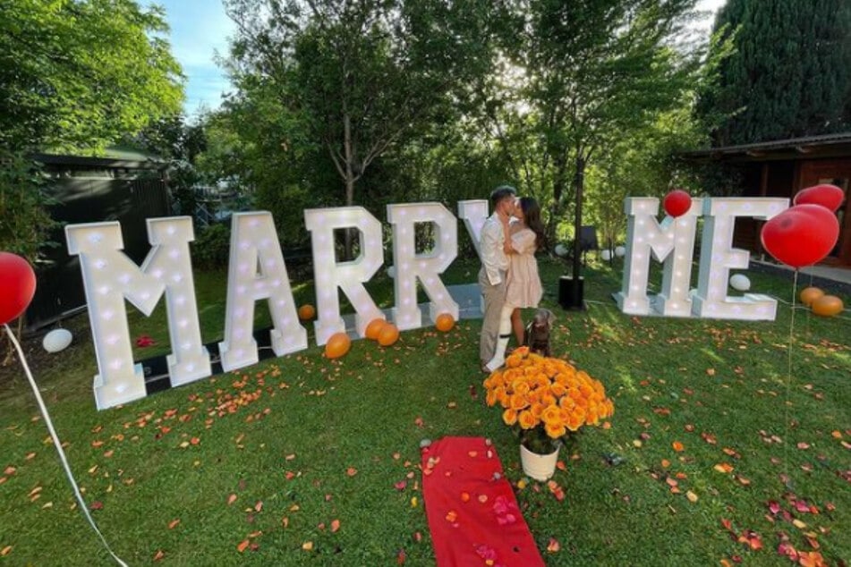 Daniele Negroni (27) hat vor einem großen "Marry me"-Schriftzug um die Hand seiner Freundin Davina angehalten.