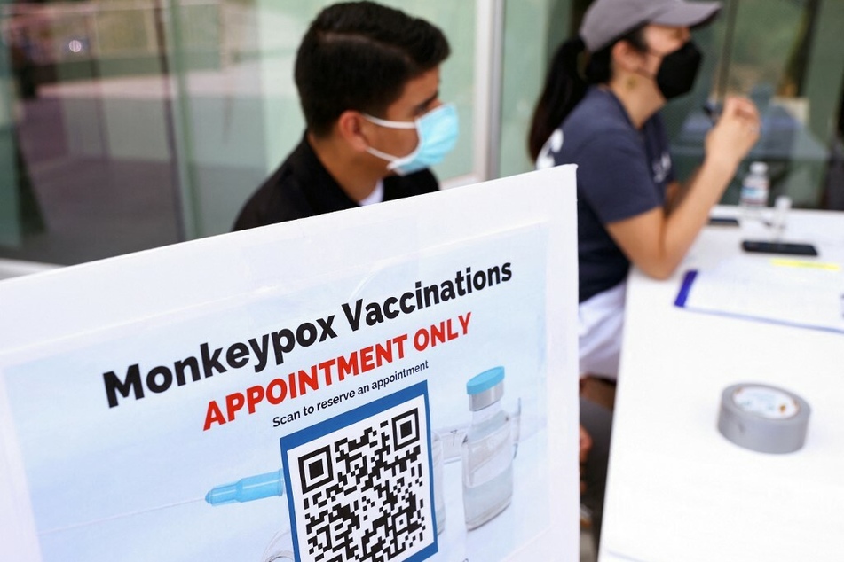 Health workers sit at a check-in table at a pop-up monkeypox vaccination clinic in West Hollywood, California.