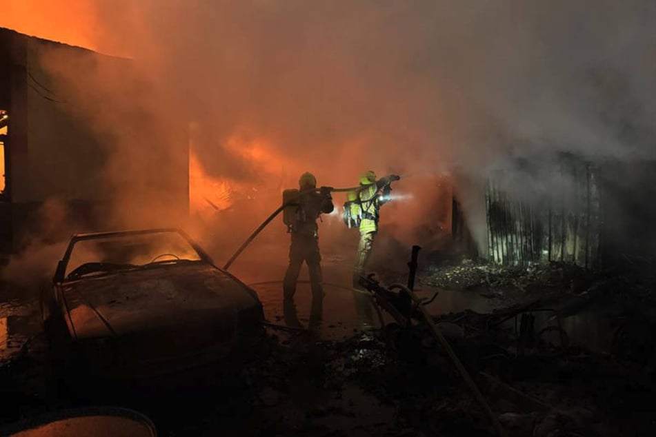 Die Feuerwehrleute bekämpfen die Flammen mit mehreren Löschtrupps auf der Vorder- und Rückseite der Gebäude.