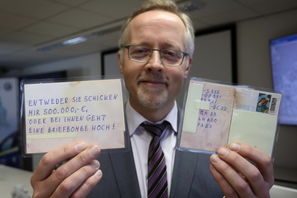 Josef Ischwang, Leiter der Kriminalpolizeiinspektion Kempten, zeigt Postkarten des Erpressers.