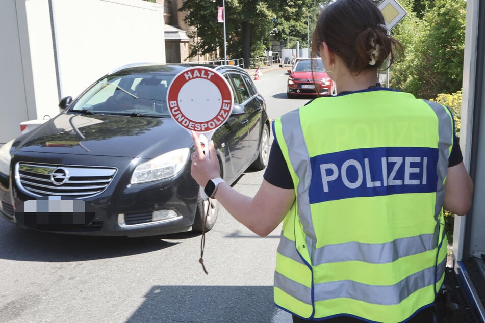 Mit der Kelle werden einzelne Autos aus der Schlange gezogen.