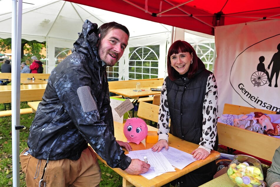 Anwohner Lars Zeidler (39) und Yvonne Killian (45, FDP) bei der Unterschriftenaktion auf dem Stadtteilfest Schönau.