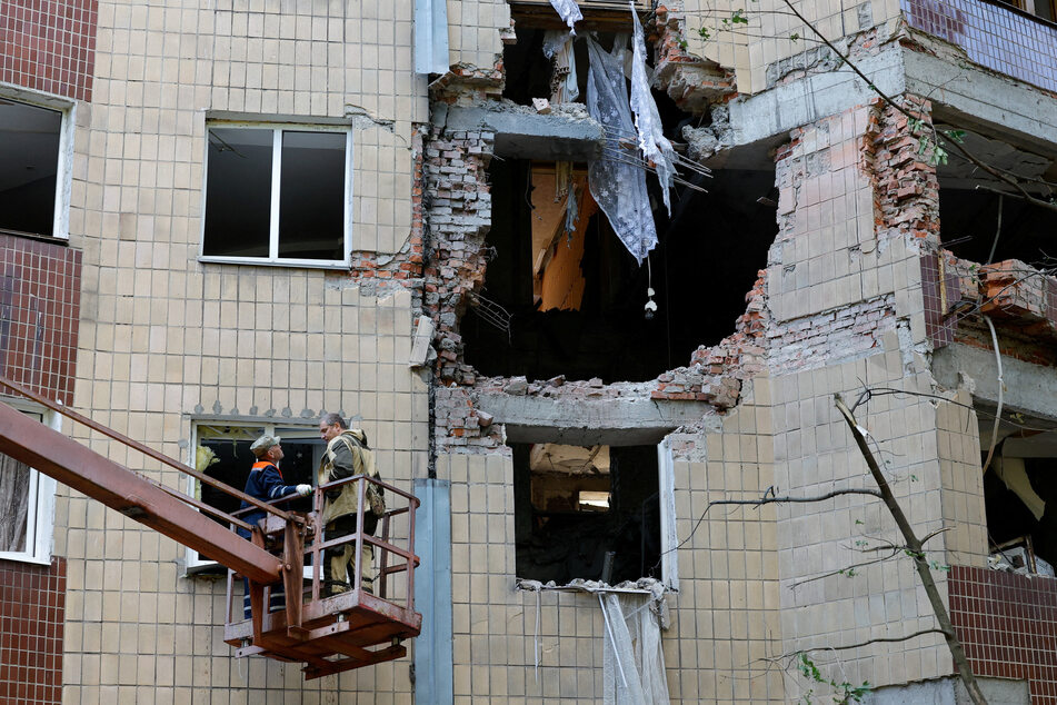 Workers remove debris in a block of apartments damaged by overnight shelling in Donetsk, a Russian-controlled city of Ukraine, on August 16, 2025