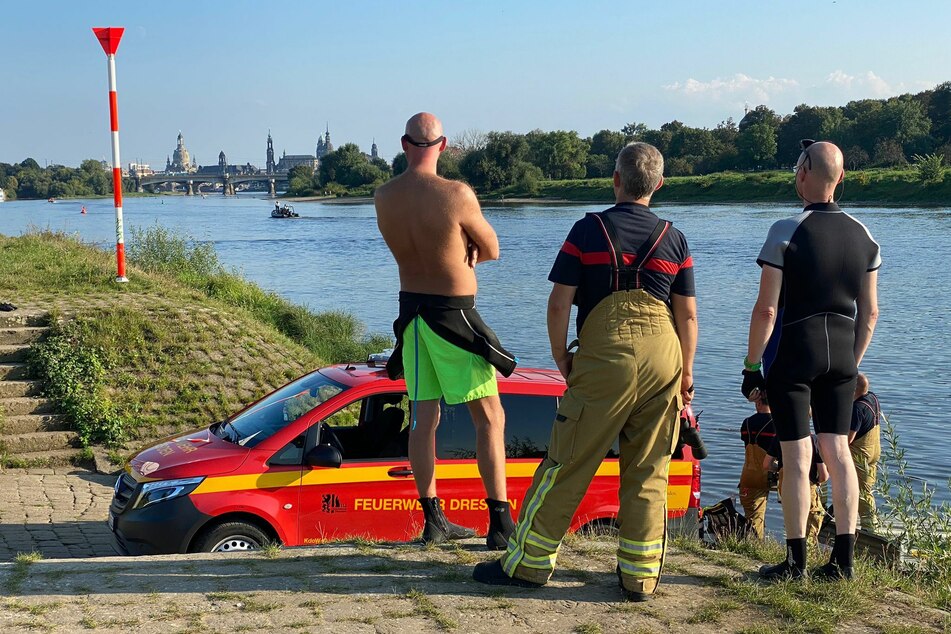 Einsatzkräfte halten Ausschau nach der Person in der Elbe.