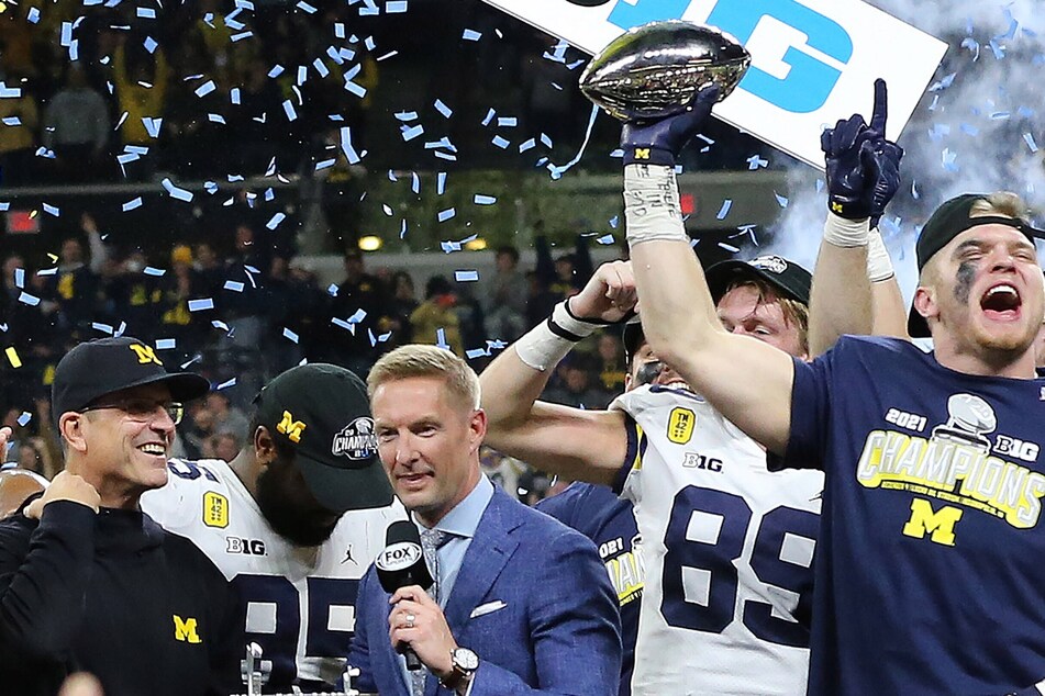 Aidan Hutchinson (r) celebrated with the Big Ten Trophy after defeating the Iowa Hawkeyes in the Big Ten Championship Game.