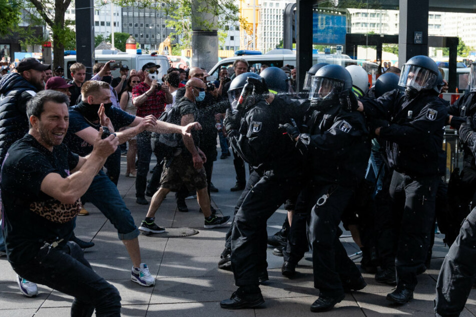 Polizisten gehen mit Pfefferspray gegen Demonstranten vor.