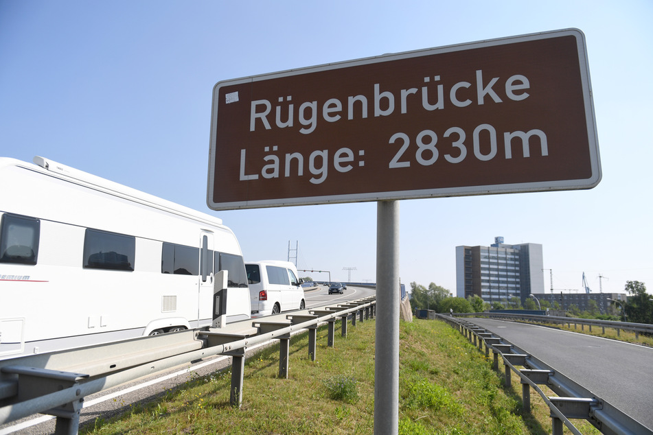 Ein Pkw mit Wohnanhänger fährt über die Rügenbücke auf die Insel Rügen.