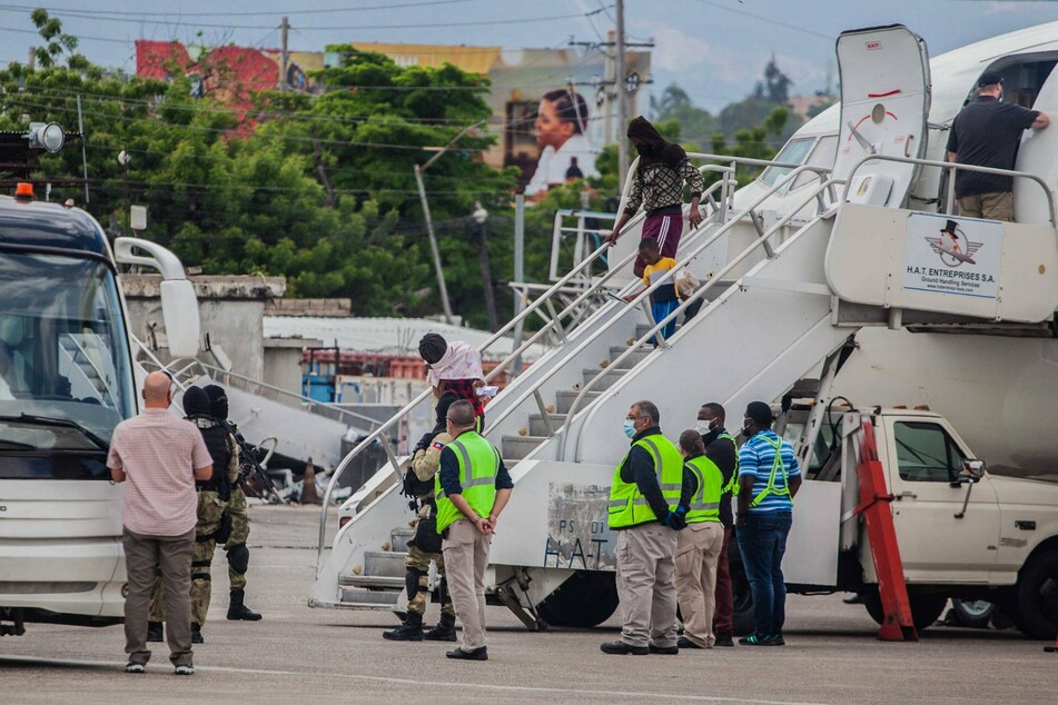Haitian migrants descend a plane after being deported from the US.