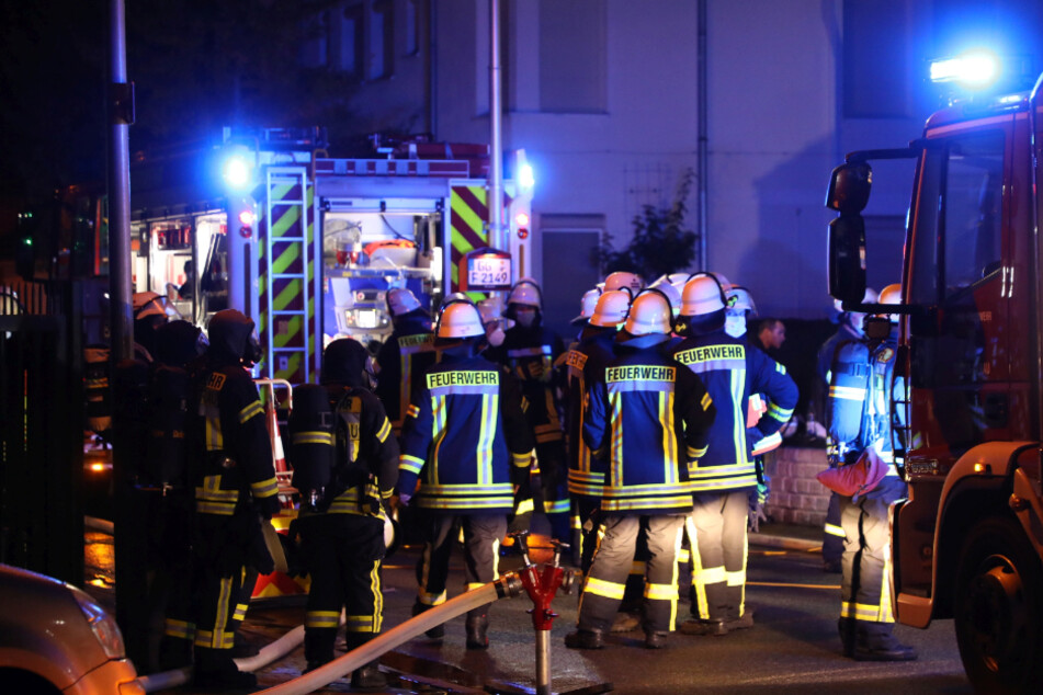 Einsatzkräfte stehen vor den Löschfahrzeugen.
