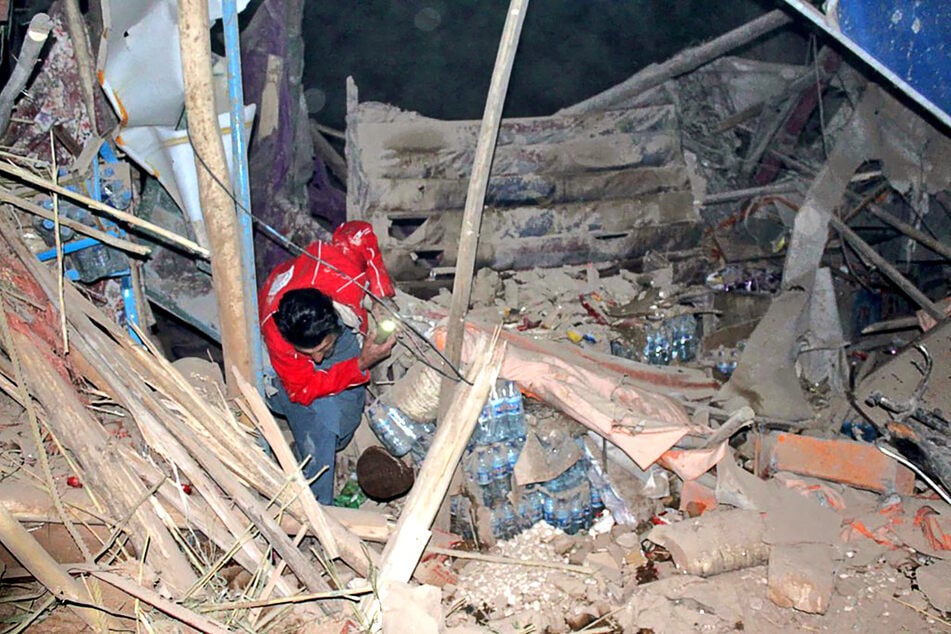 Ein Retter ist in einem, von dem Erdbeben betroffenen, Gebiet unterwegs.