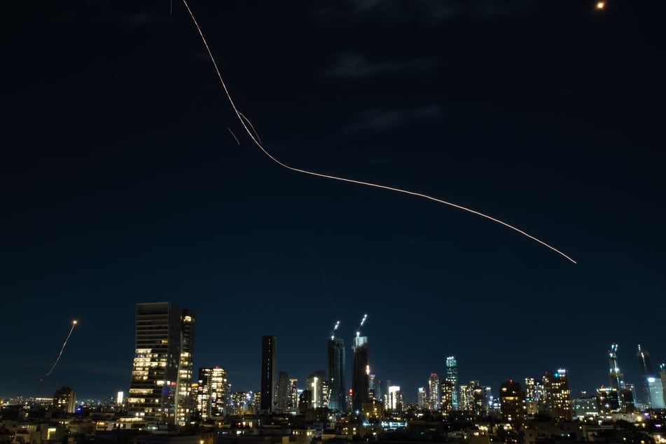 Dese Langzeitaufnahme zeigt die Leuchtspuren von Abfangraketen, die von israelischen Luftverteidigungssystemen abgeschossen wurden.