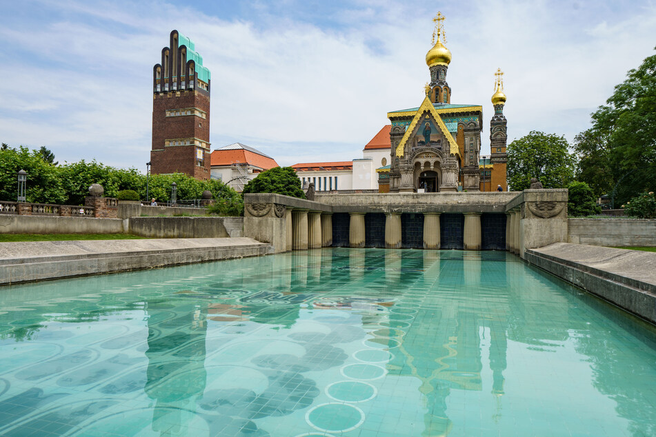 Der Hochzeitsturm (l.), das Ausstellungsgebäude (M.) und die russische Kapelle (r.) spiegeln sich auf der Mathildenhöhe im Lilienbecken.