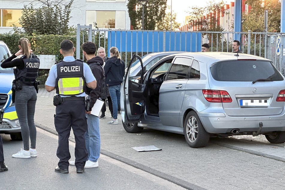 Die Polizei ist mit einem Großaufgebot vor Ort. Im Hintergrund ist der Mercedes des Opfers mit durchschossener Heckscheibe zu sehen.