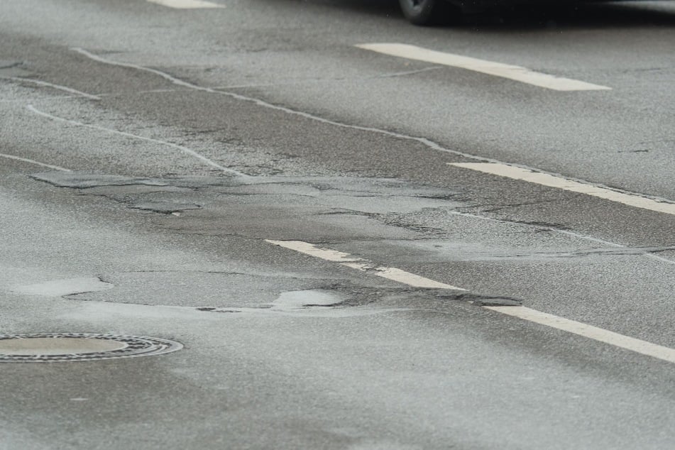 Der Asphalt ist stark abgenutzt und stellenweise eingerissen.