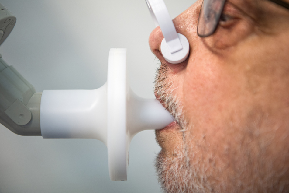 Ein Mann sitzt zur Überprüfung seiner Lungenfunktion in einem Bodyplethysmographen. In einer Klinik am Teutoburger Wald werden Long-Covid-Patienten behandelt. Eine entsprechende Therapie soll langfristig aus Baden-Württemberg kommen. (Symbolbild)