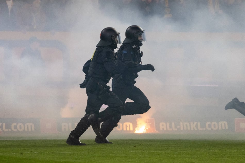 Platzsturm der Polizei. Anhänger von Hertha BSC hatten zuvor Fans von Dynamo Dresden angegriffen.