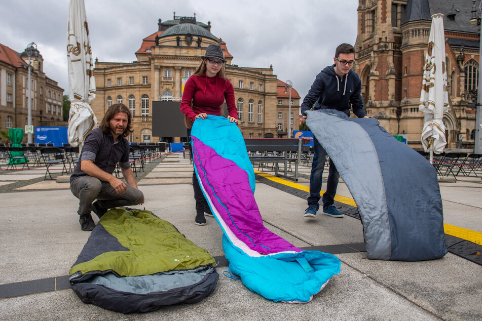 Filmnächte-Veranstalter Michael Claus (42), Janice Schmelzer (16) und ihr Freund Yannik Hinze (17) rollen die Schlafsäcke auf dem Theaterplatz aus.