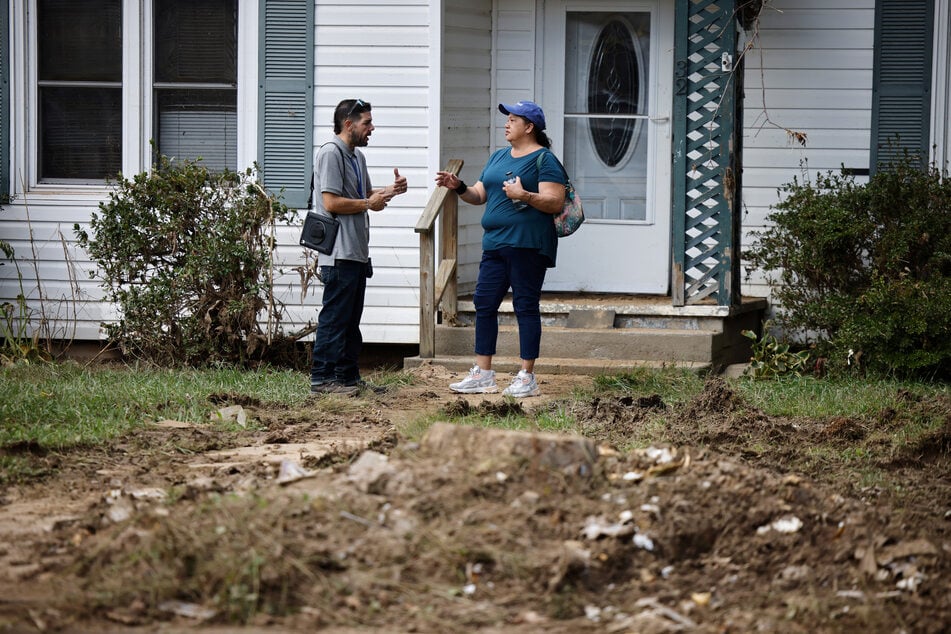 A FEMA employee speaks to a woman whose house she was renting was badly damaged by flooding from Hurricane Helene in Canton, North Carolina.