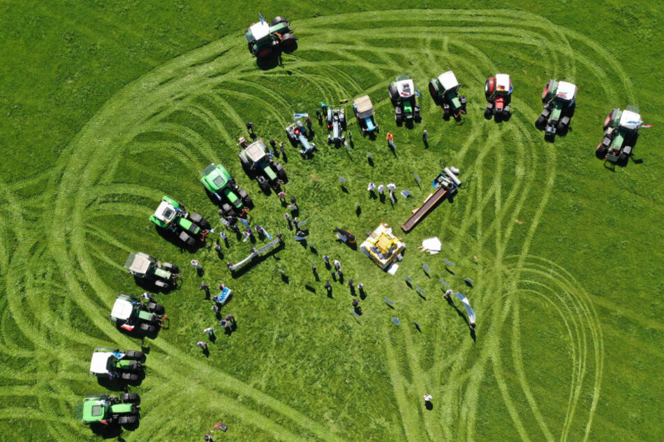 Traktoren stehen bei einer Protestaktion des Bundesverbandes der Deutschen Milchviehhalter (BDM) um eine Pyramide aus Milchpulversäcken.
