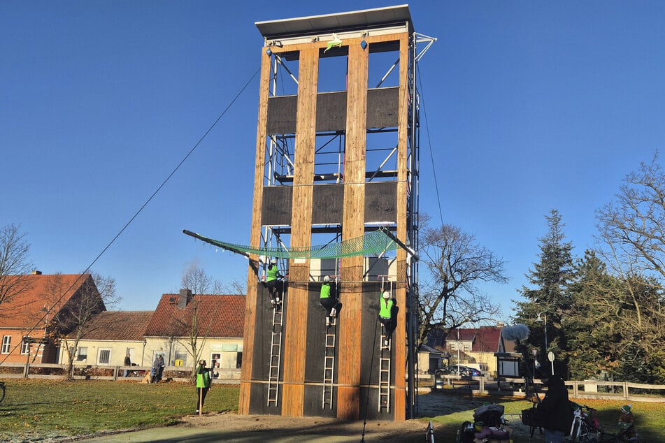 Am Steigerturm trainieren Feuerwehrsportler das Hakenleitersteigen.