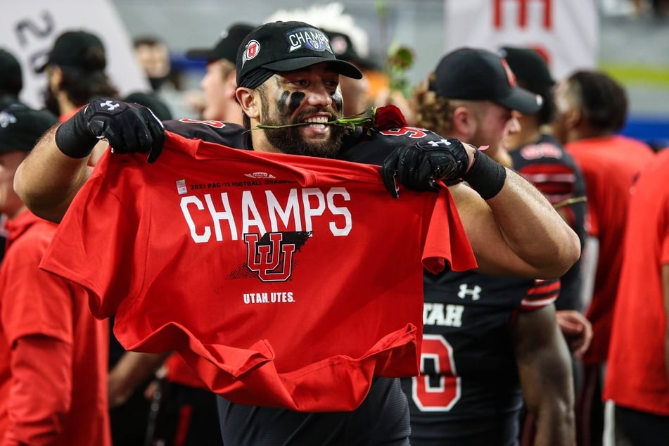 Utes defensive tackle Devin Kaufusi holds up a Champs shirt at the conclusion of the PAC-12 Football Championship Game.