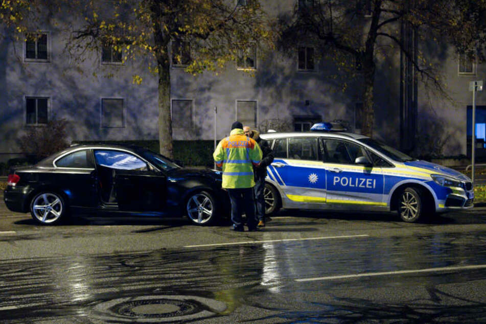 Polizisten stehen nach der Tragödie neben dem BMW, in dem der Angeklagte den folgenschweren Unfall verursachte. (Archiv)