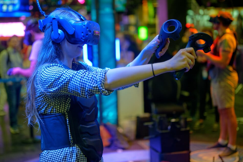 Eine Besucherin testet auf der Gamescom mit einer VR-Brille ein Computerspiel. (Archivbild)