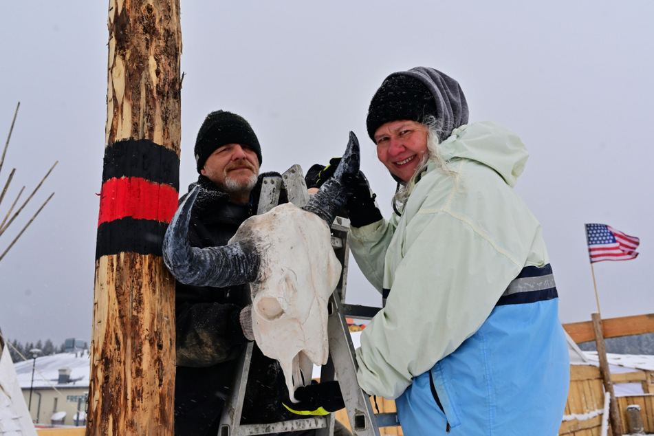 Martina (54, r.) und Reiner Summer (52) befestigen Büffelschädel am Marterpfahl im "Lakota - Indianerdorf".