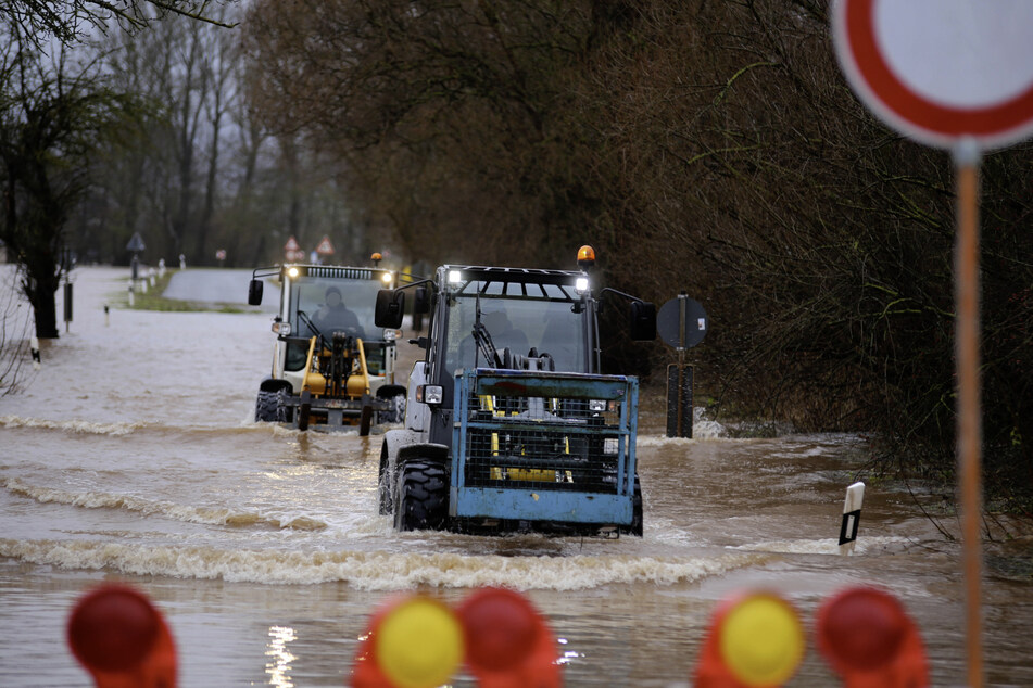Der Ort Windehausen ist vom Wasser komplett eingeschlossen. Zwei Traktoren verlassen den Ort über eine von Hochwasser überflutete Straße.