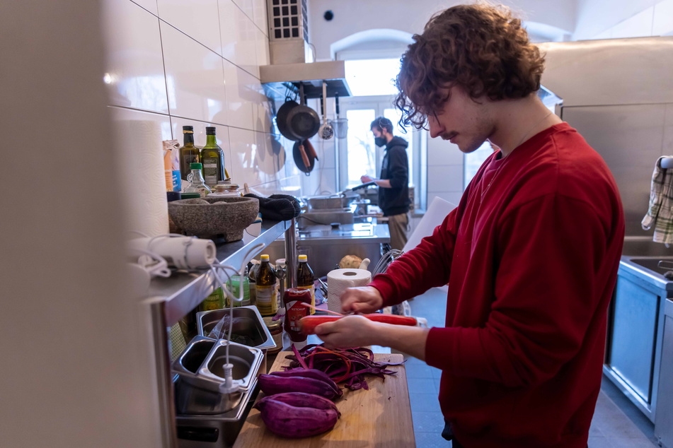 Psychologie-Student Robin Lögler (23) schneidet in der Küche in der Zietenstraße Gemüse.