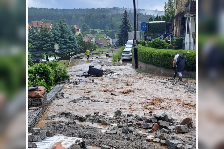 Der braune Strom hat Steine aus der Straße gerissen, Strom und Wasserleitung wurden freigelegt.