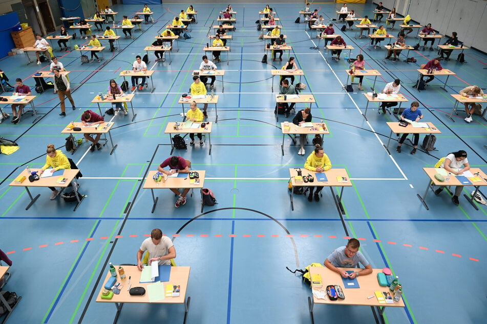 Schüler und Schülerinnen sitzen während der Deutsch-Abiturprüfung mit dem vorgeschriebenen Abstand zueinander in vor ihren Aufgaben.