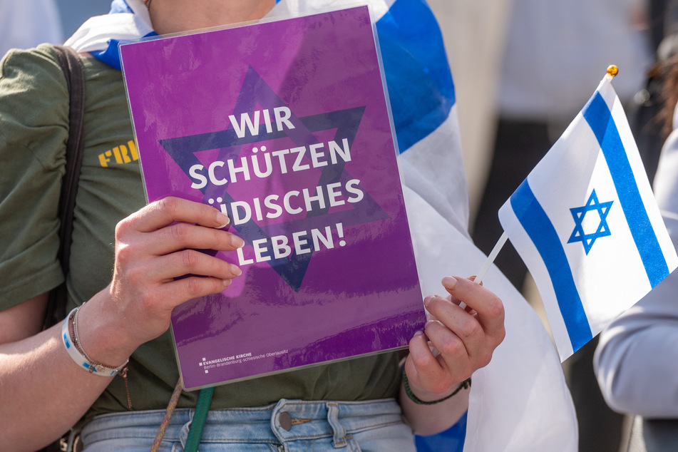 Mit A4-Blättern und der Aufschrift "Wir schützen jüdisches Leben" machten die Menschen vor der Humboldt-Uni auf sich aufmerksam.
