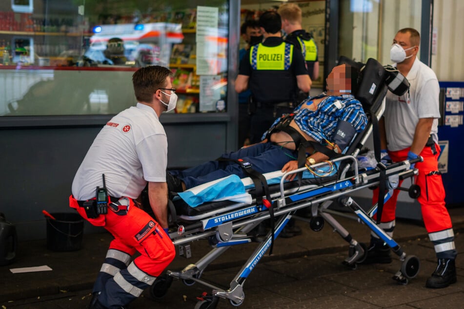 Rettungskräfte transportieren einen verletzten Mann ab. An der Tankstelle war es zu einer Auseinandersetzung gekommen.
