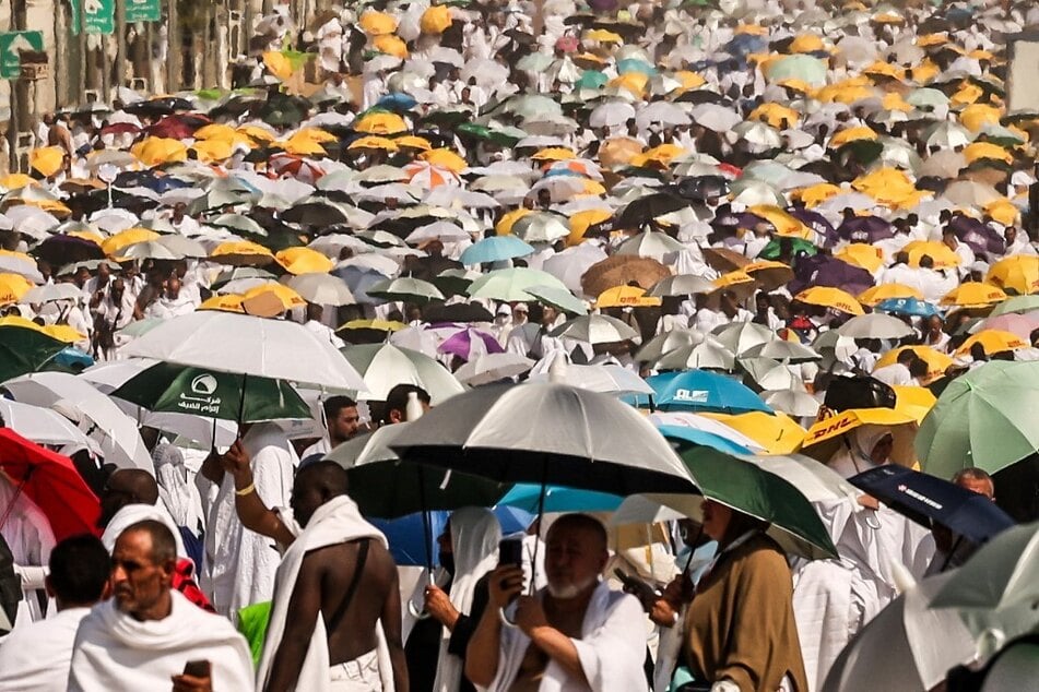 Muslim pilgrims use umbrellas to shade themselves from the sun as they arrive at the base of Mount Arafat, also known as Jabal al-Rahma or Mount of Mercy, during the annual Hajj pilgrimage.