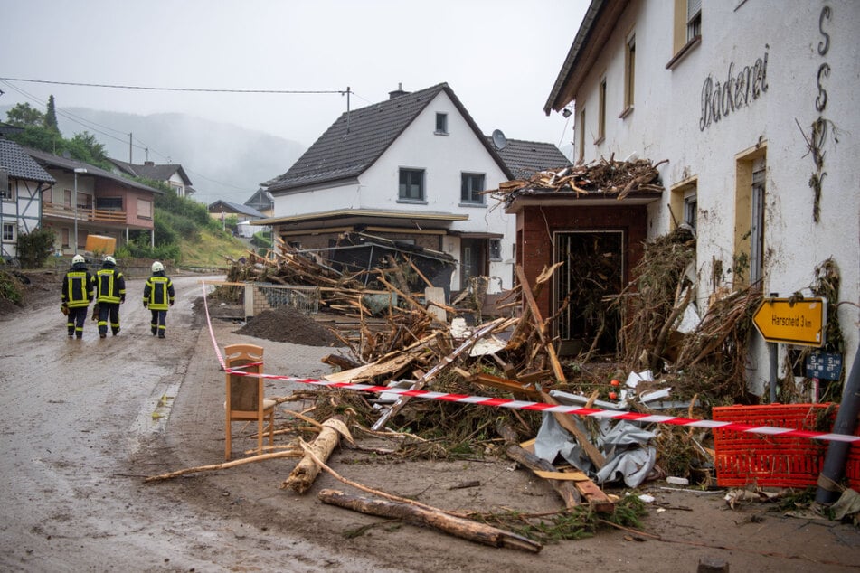 Feuerwehrleute gehen durch den verwüsteten Ortskern von Schuld in Rheinland-Pfalz. Nach dem verheerenden Unwetter hat Thüringen Hochwasserhilfe in das gebeutelte Bundesland geschickt.