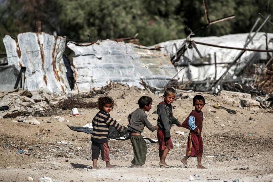 Palestinian children play together near shacks in Khan Younis in the southern Gaza Strip amid Israel's ongoing genocide.