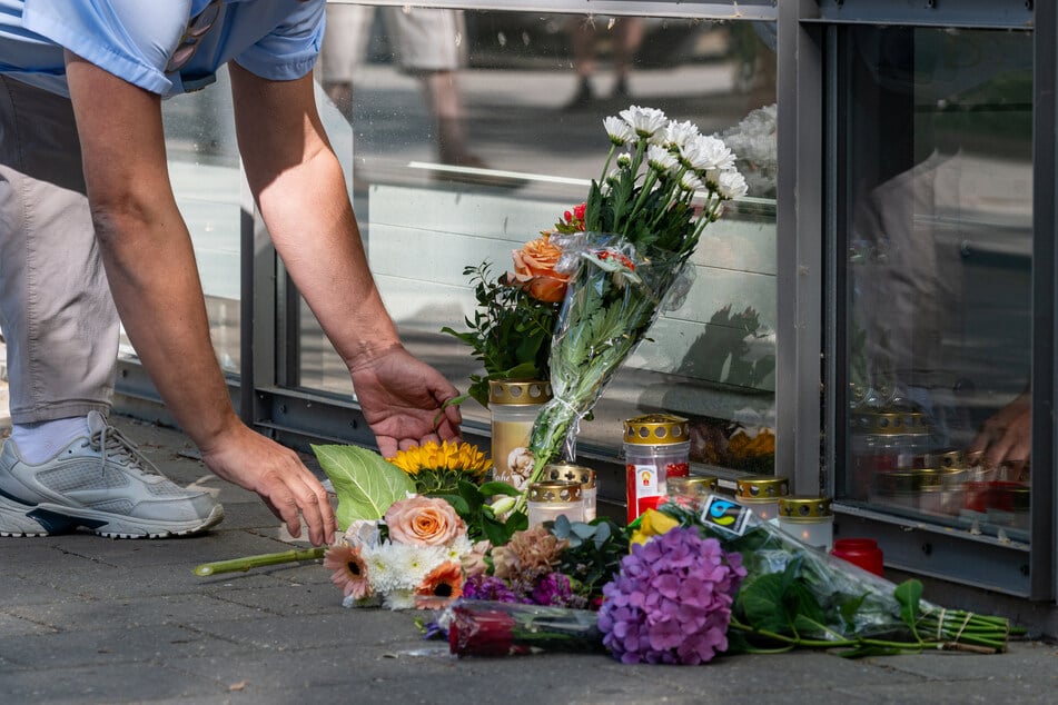 Blumen und Kerzen wurden vor der Bankfiliale in Regensburg niedergelegt.