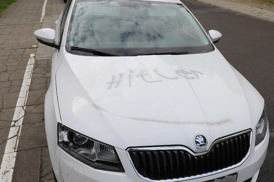 Der Schriftzug "Hitler" steht auf einem am Straßenrand abgestellten Fahrzeug.