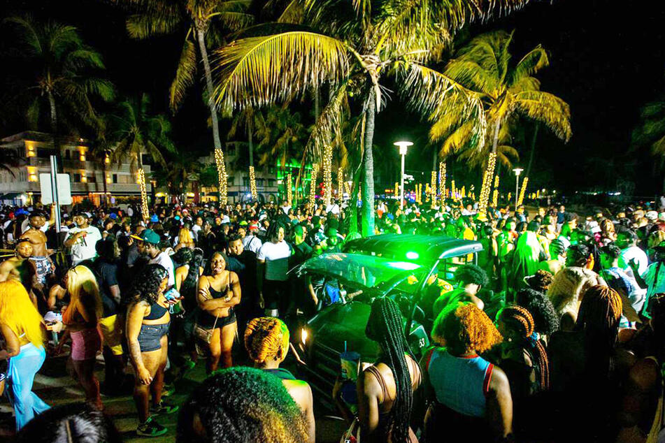 The police drive through the celebrating crowd on Miami Beach. In the background is Ocean Drive, which has been a pedestrian zone since the coronavirus pandemic.