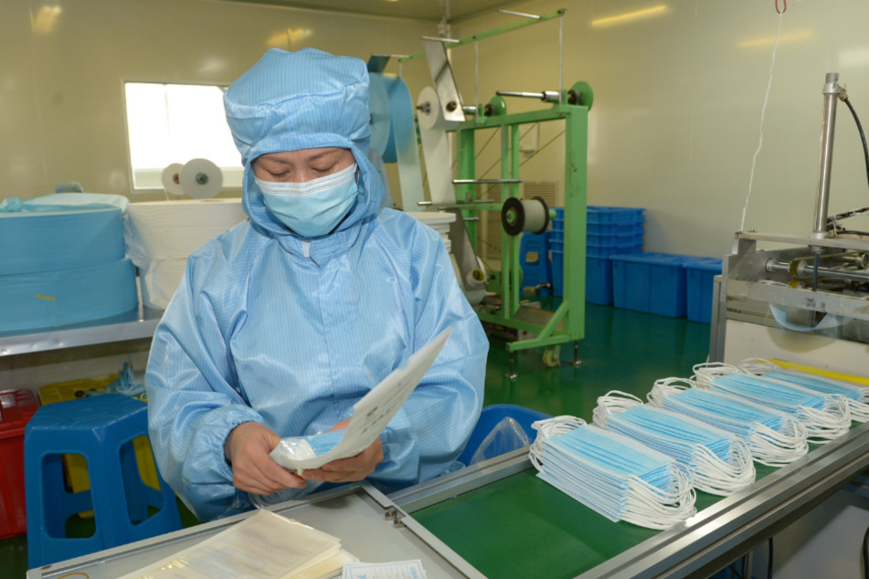 Eine Mitarbeiterin verpackt Schutzmasken in einem Betrieb eines Unternehmens, das medizinische Produkte herstellt.