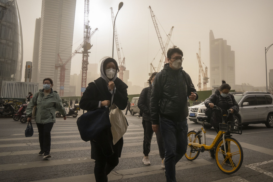 Menschen schützen sich vor der verschmutzten Luft mit Masken.