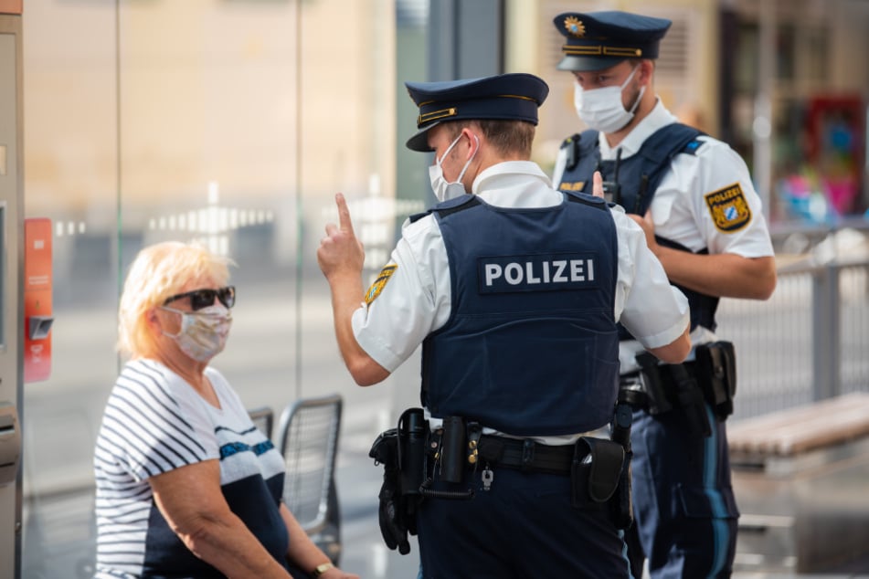 Polizisten belehren eine Frau nach einem Verstoß gegen die Maskenpflicht im öffentlichen Nahverkehr. (Symbolbild)