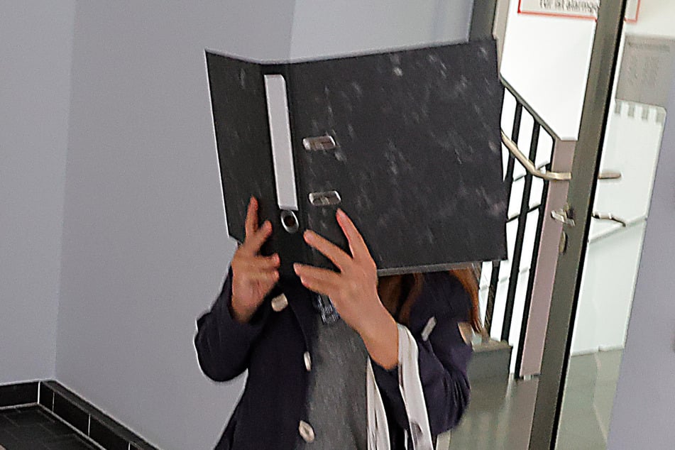 Nikola H. (48) verbarg ihr Gesicht hinter einem Akten-Ordner. Ihr wird Beihilfe und Geldwäsche vorgeworfen.