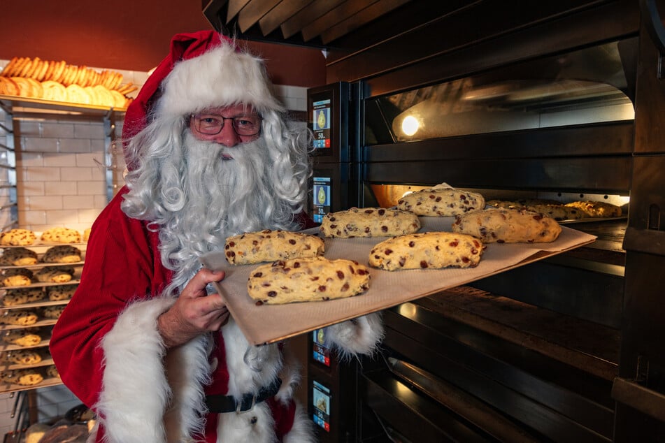 In voller Weihnachtsmann-Montur schiebt KeXerei-Chef Matthias Walther (56) Stollen in den Backofen.