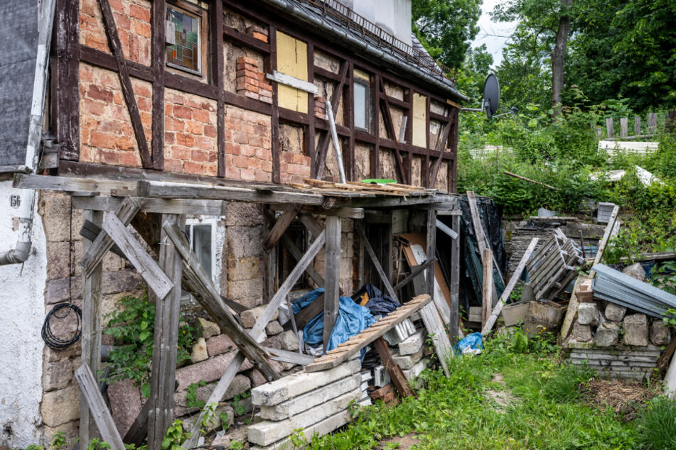 Vor dem denkmalgeschützten, baufälligen Gebäude sieht es aus wie in einer Rumpelkammer.